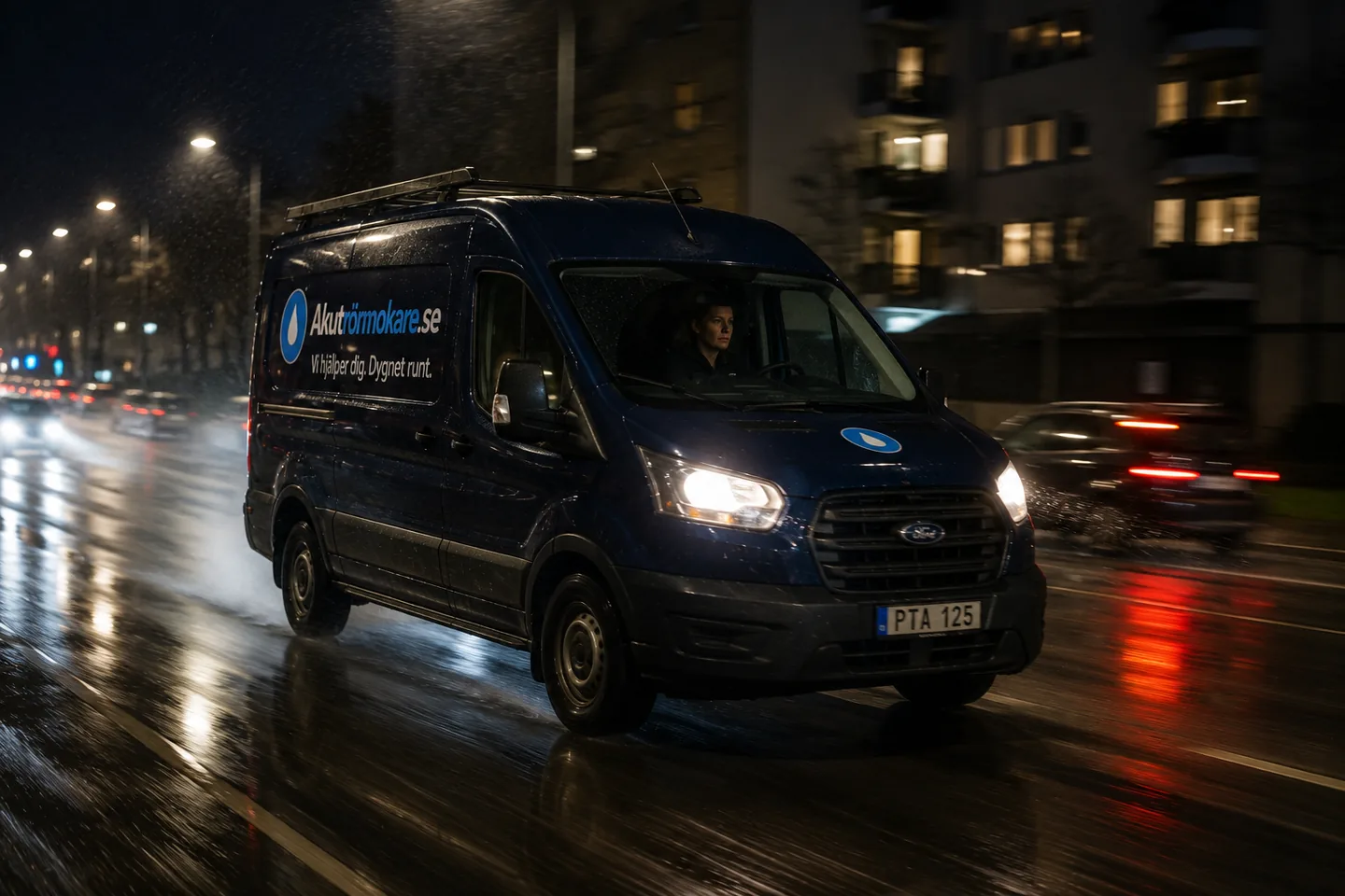 Servicebil på väg genom regnet i mörker mot ett akut uppdrag.